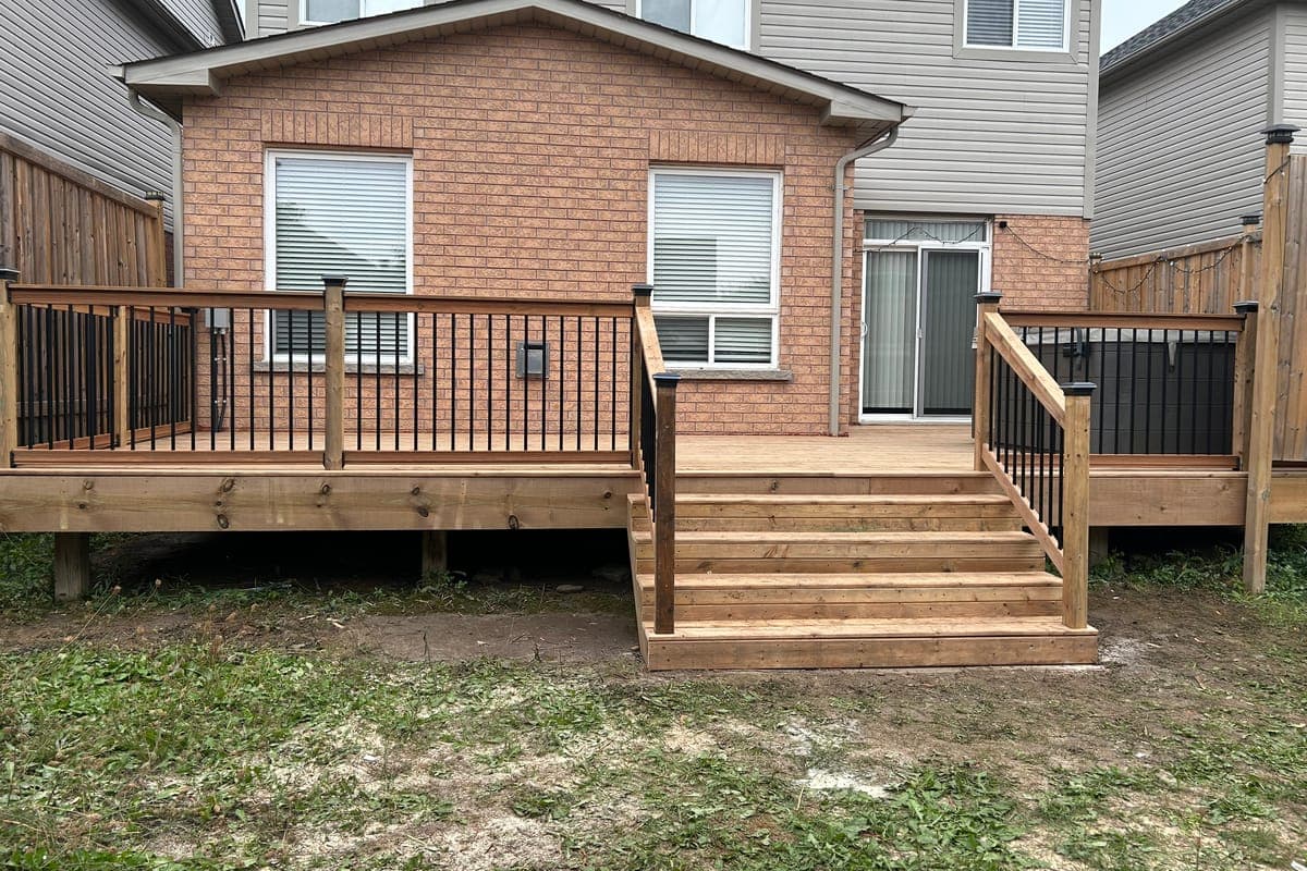 The finished deck across the back of the house, with wide stairs down to the lawn