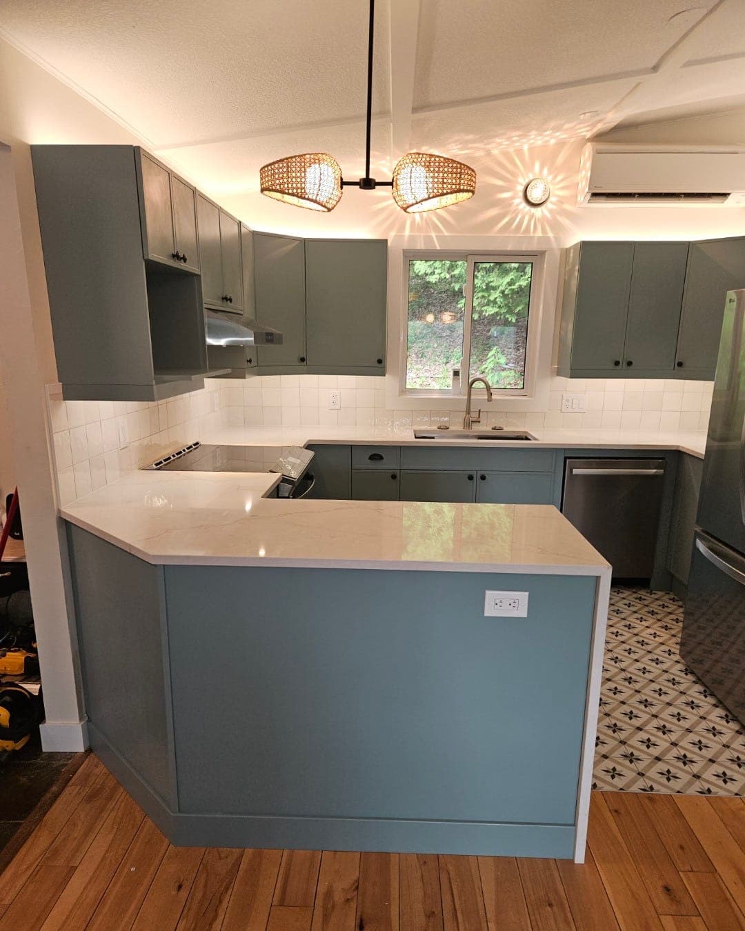 The same kitchen after: Sea Star cabinetry, white marble-look Silestone counters and rattan pendants